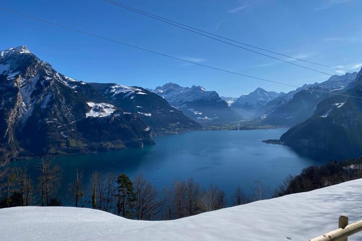 uma vista de um lago nas montanhas com neve