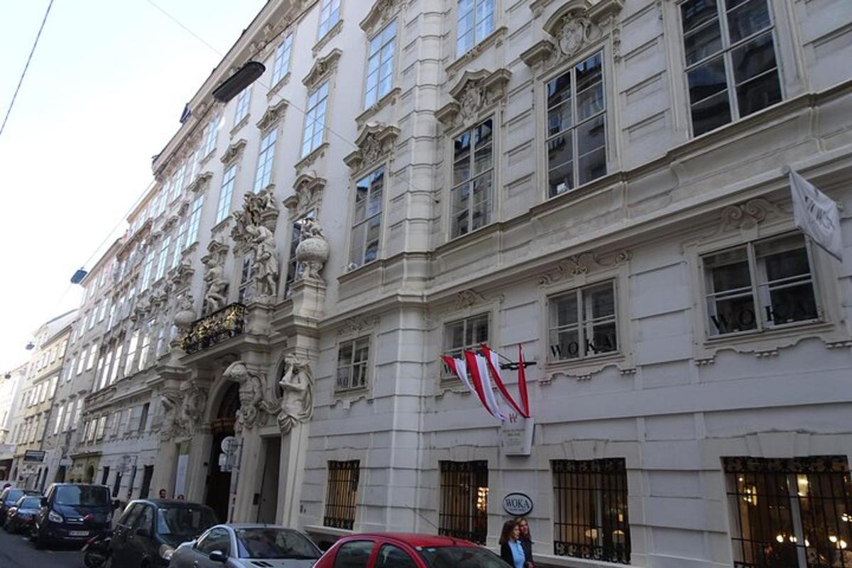 ένα μεγάλο λευκό κτίριο με αυτοκίνητα παρκαρισμένα μπροστά του