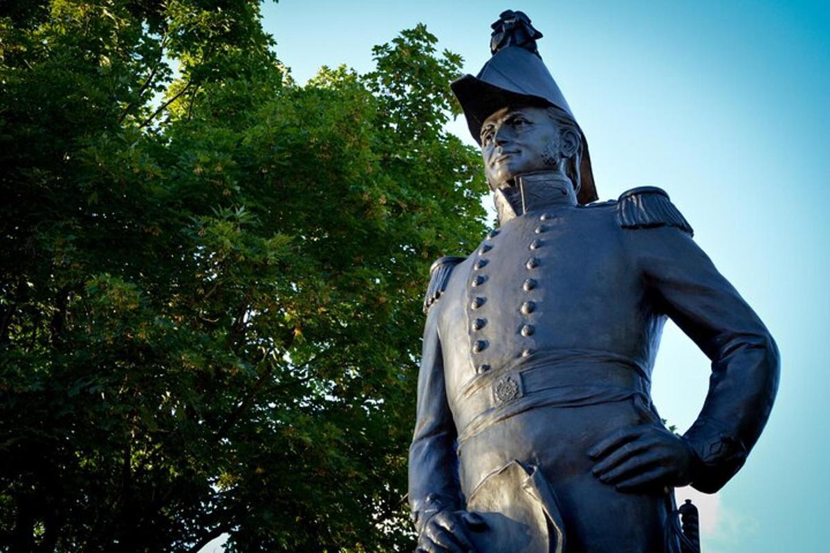 a statue of a man standing next to some trees