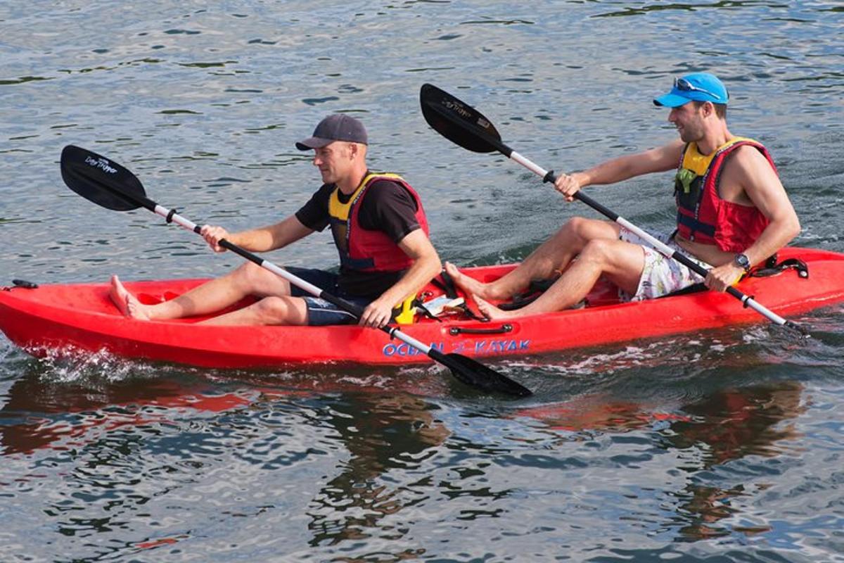 twee mannen in een rode kajak op het water