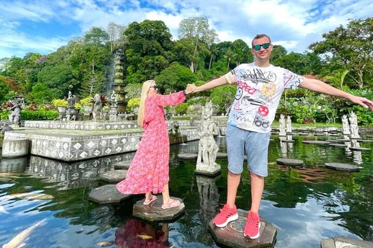 seorang lelaki dan seorang wanita berdiri di atas batu loncatan di taman