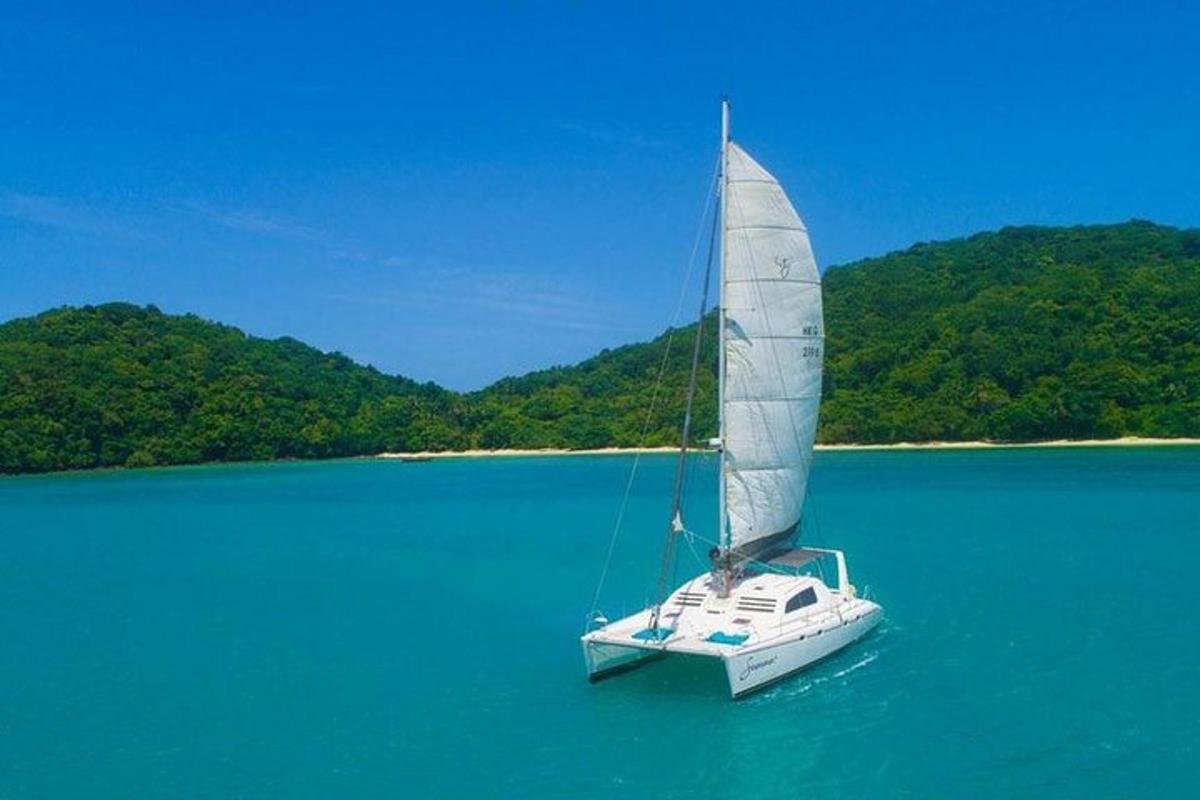 a boat with a sail in the middle of the water