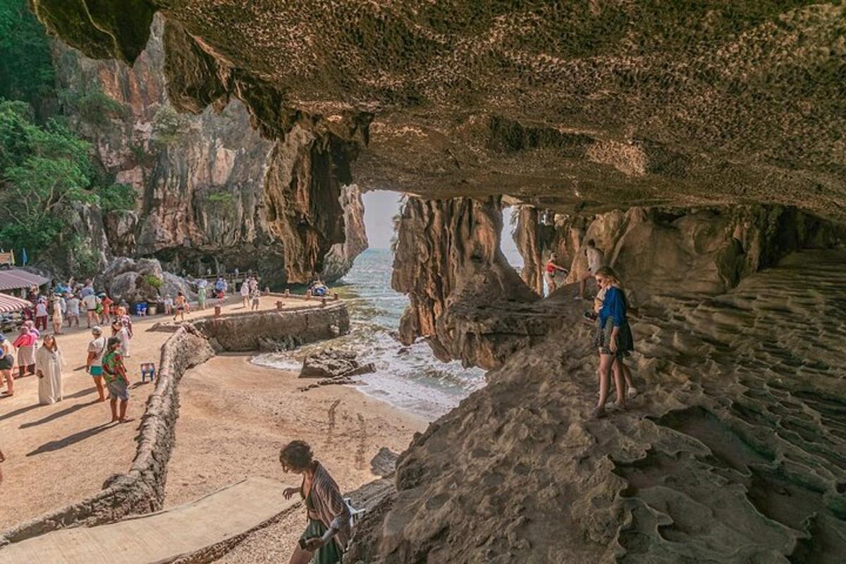 un dipinto di una spiaggia con persone in piedi sulle rocce