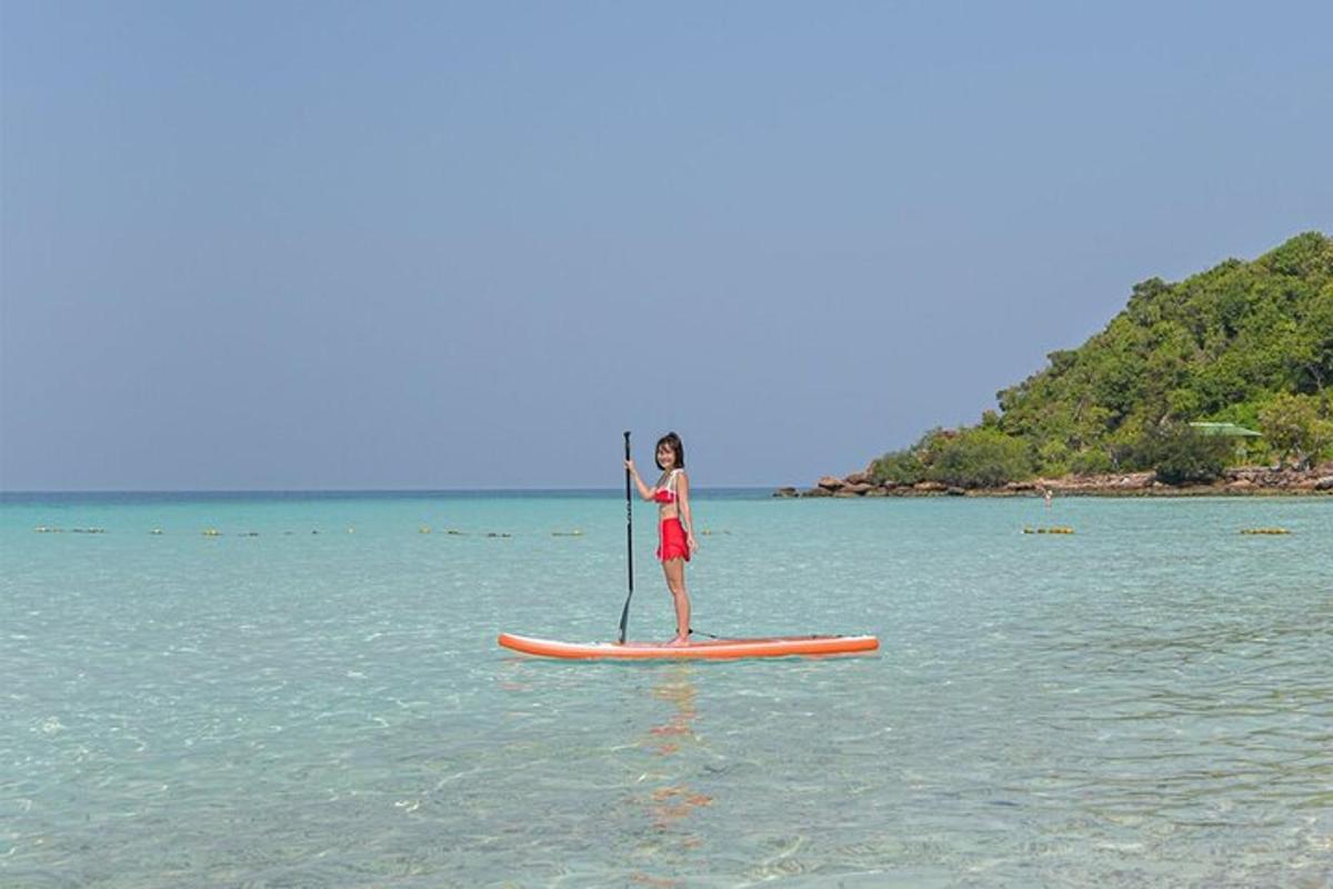 a girl is standing on a paddle board in the water