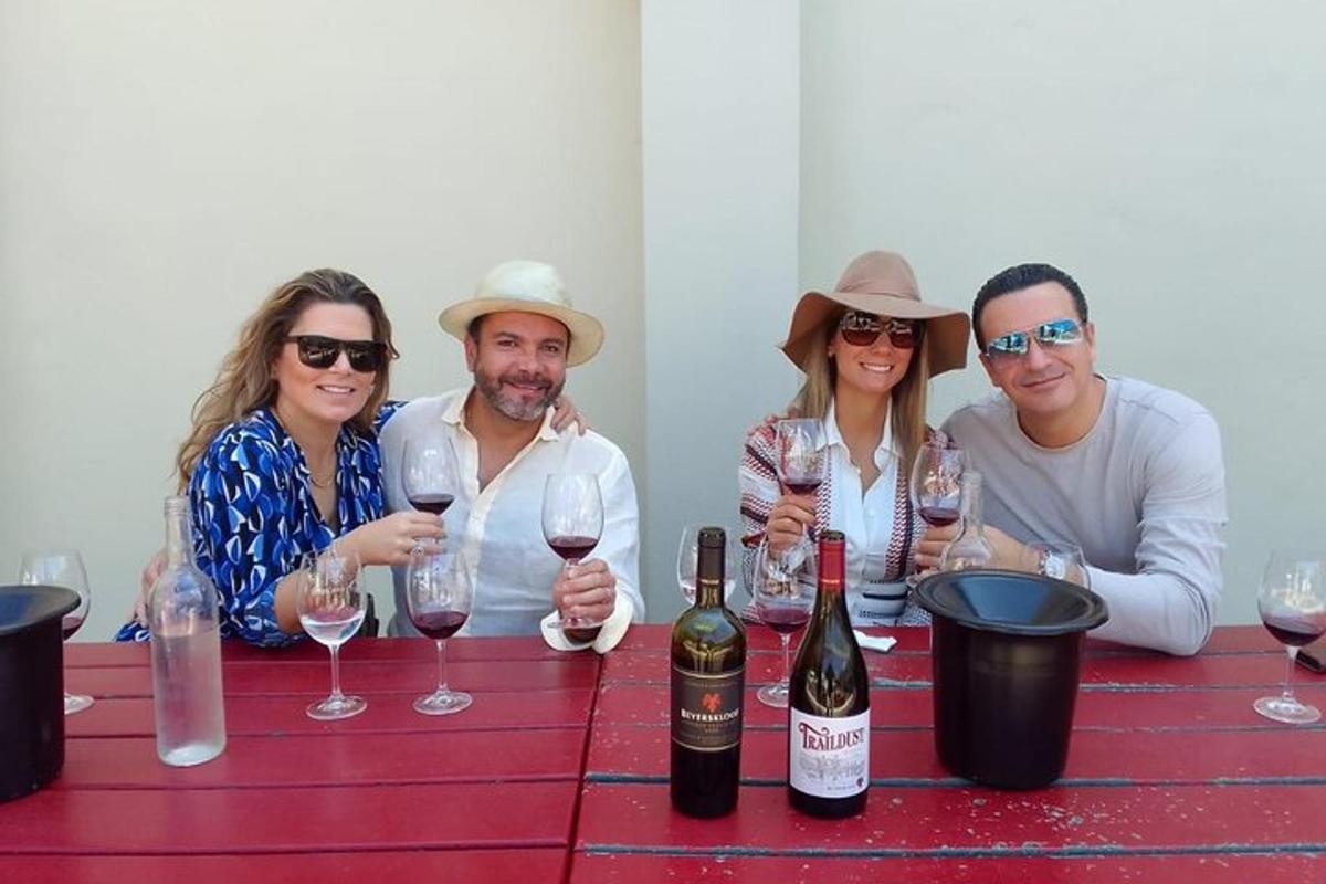 un gruppo di persone sedute a un tavolo con bicchieri di vino