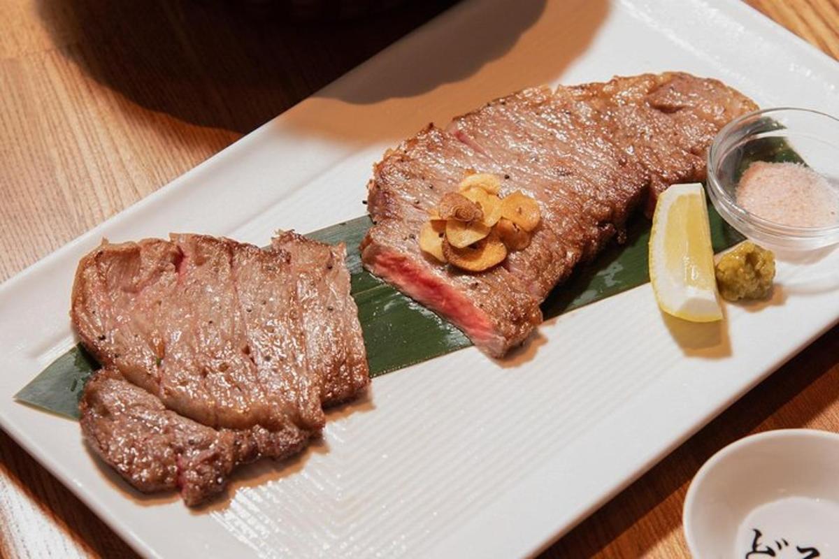 un piatto bianco con una bistecca e un pezzo di frutta