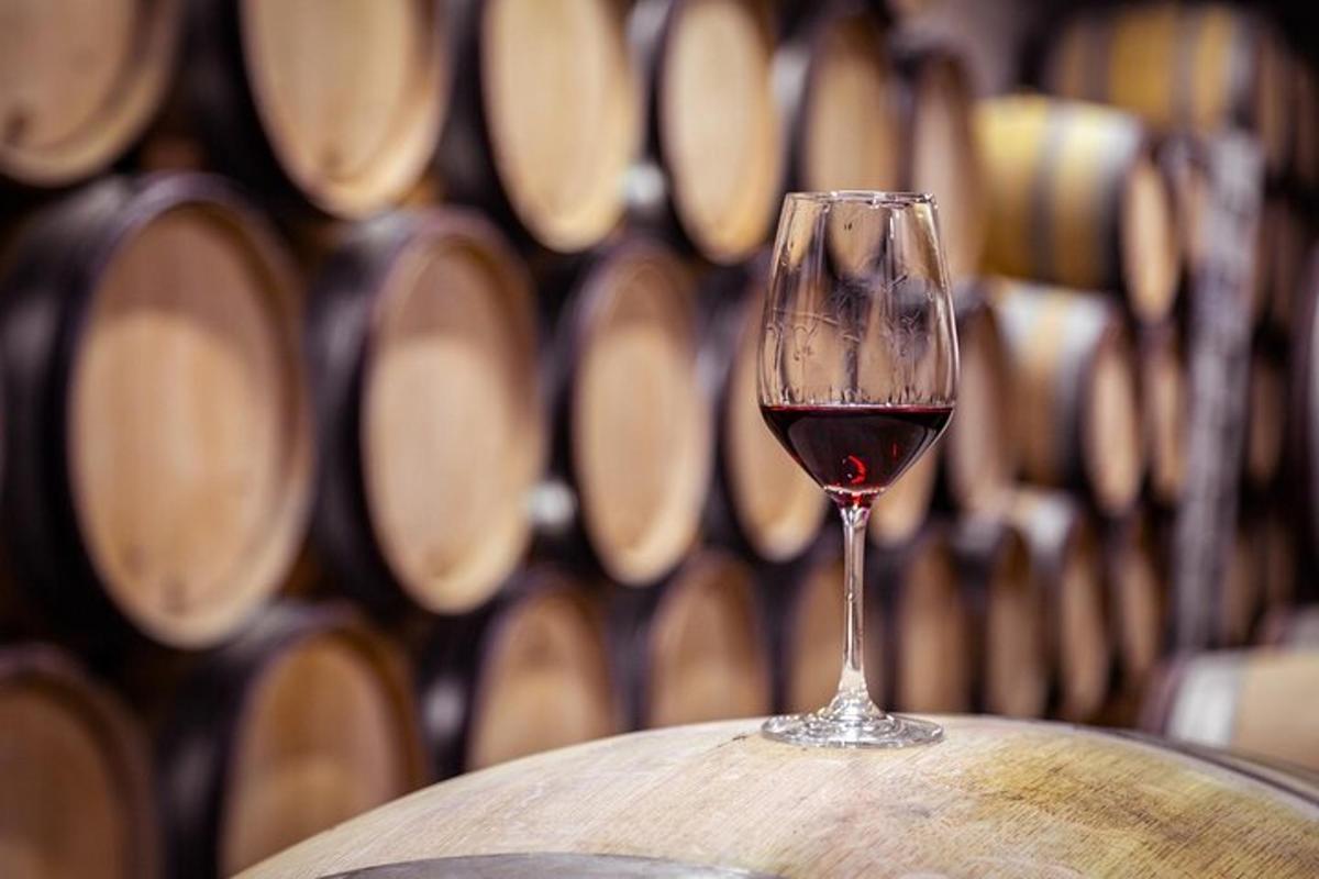 a glass of wine sitting on top of a barrel