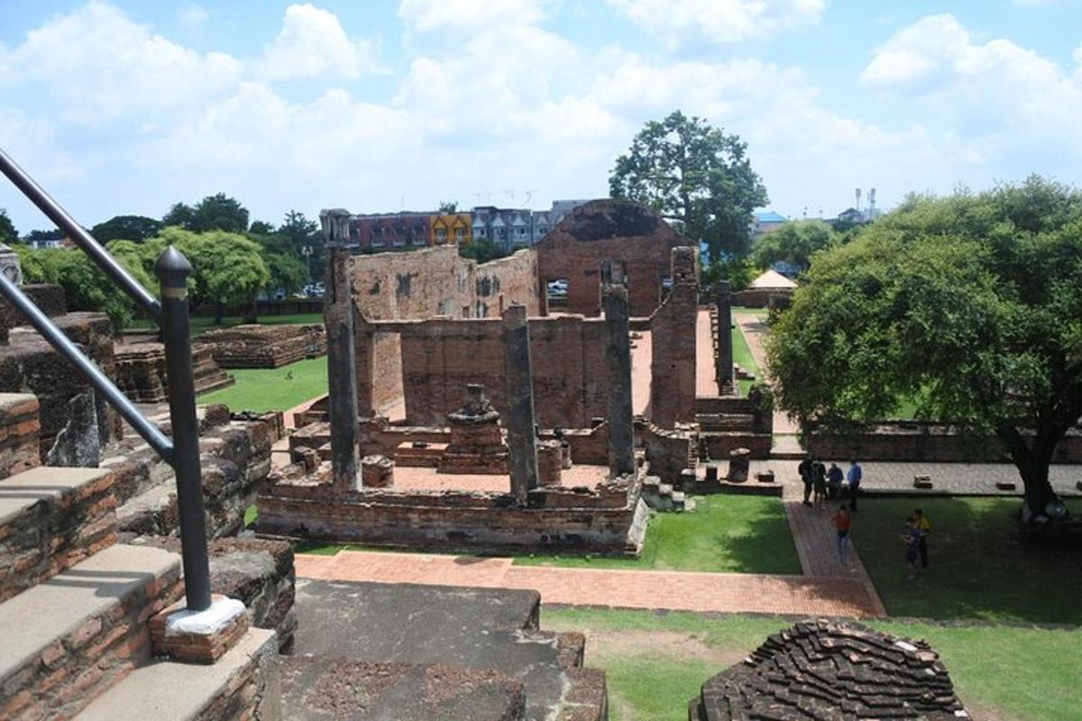Un edificio antiguo en un parque con gente caminando alrededor.