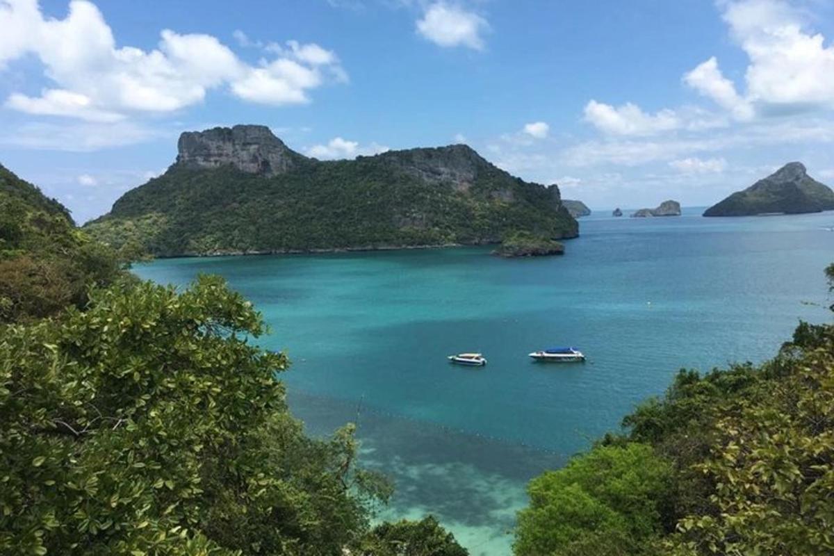 dois barcos em um grande corpo de água com montanhas