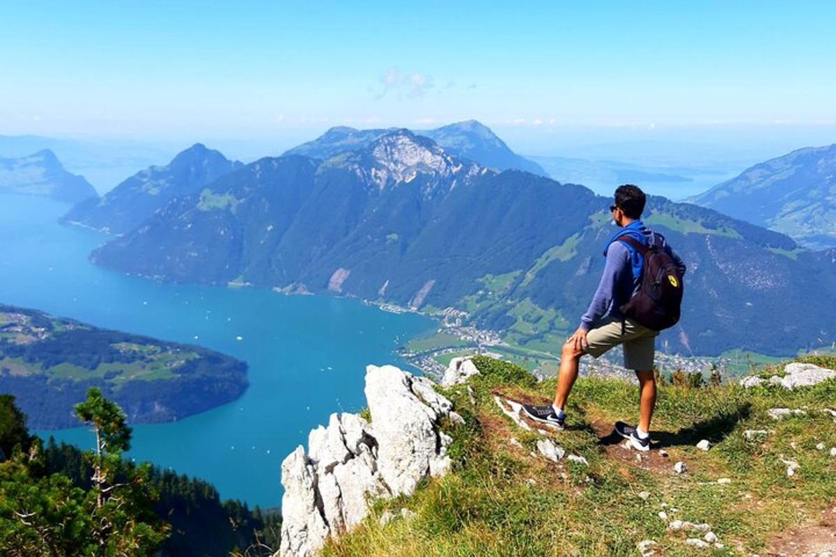 un uomo in piedi sulla cima di una montagna che domina un lago