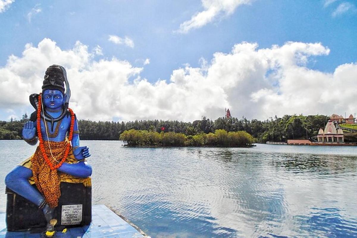 a statue sitting on the edge of a body of water