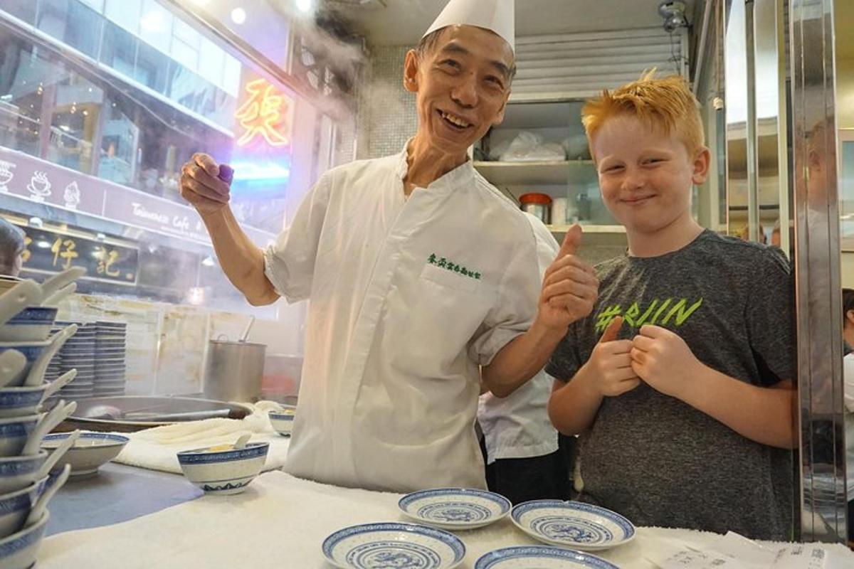 seorang lelaki berdiri di sebelah budak lelaki di dapur