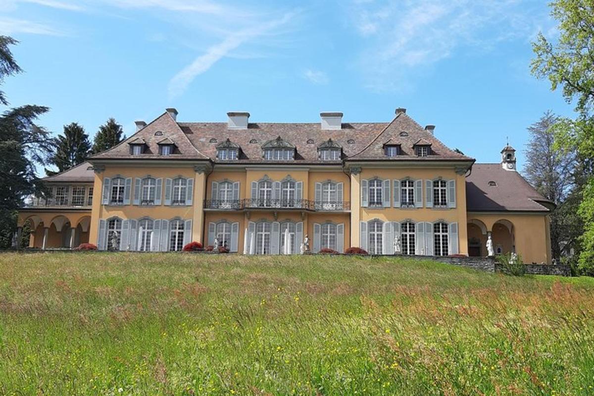 a large yellow house on top of a grassy hill