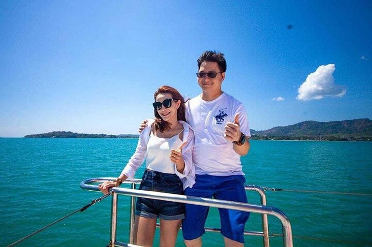 a man and woman standing on a boat in the water