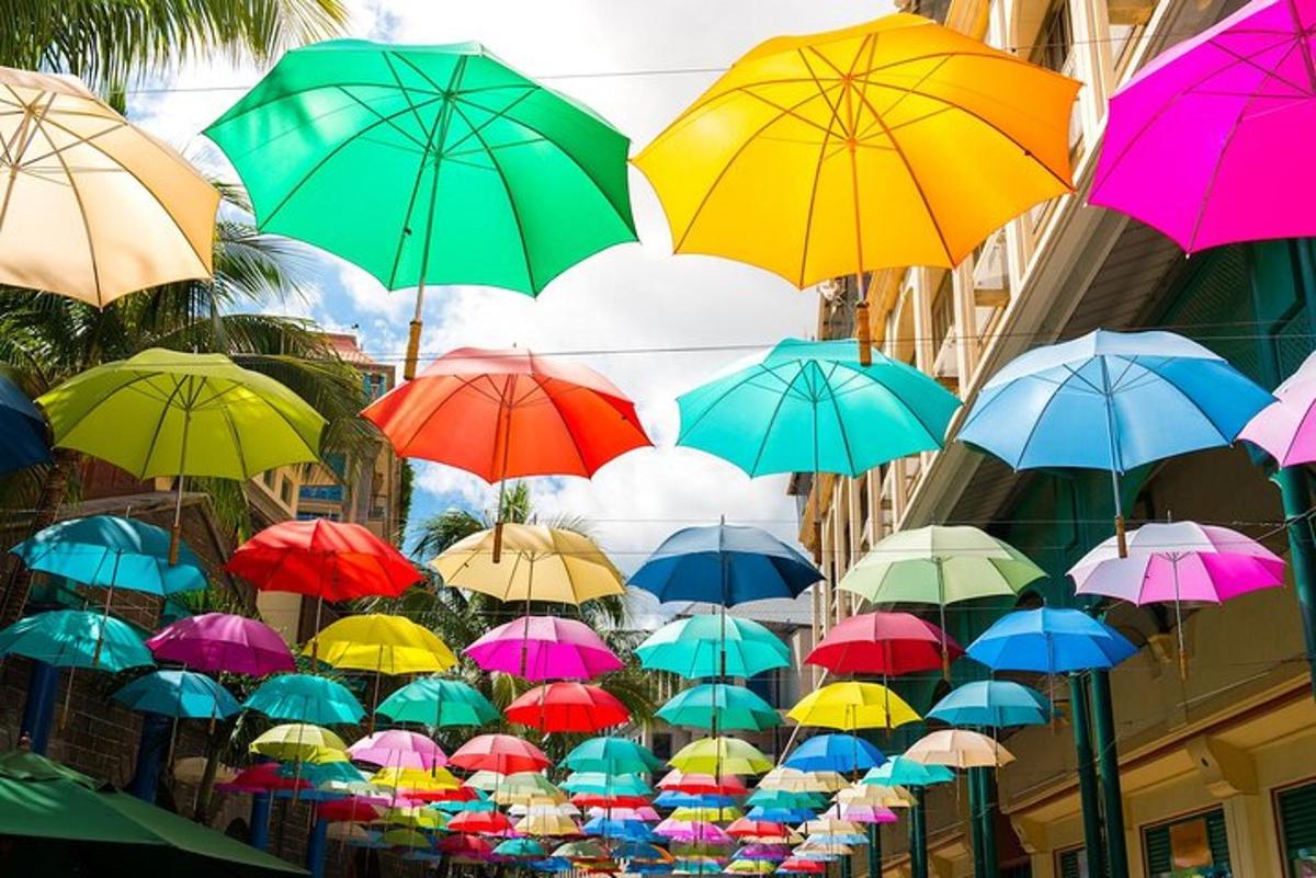 a bunch of colorful umbrellas hanging from a building