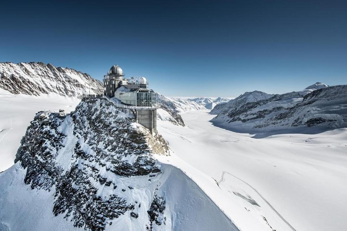 ein schneebedeckter Berg mit einem Gebäude darauf