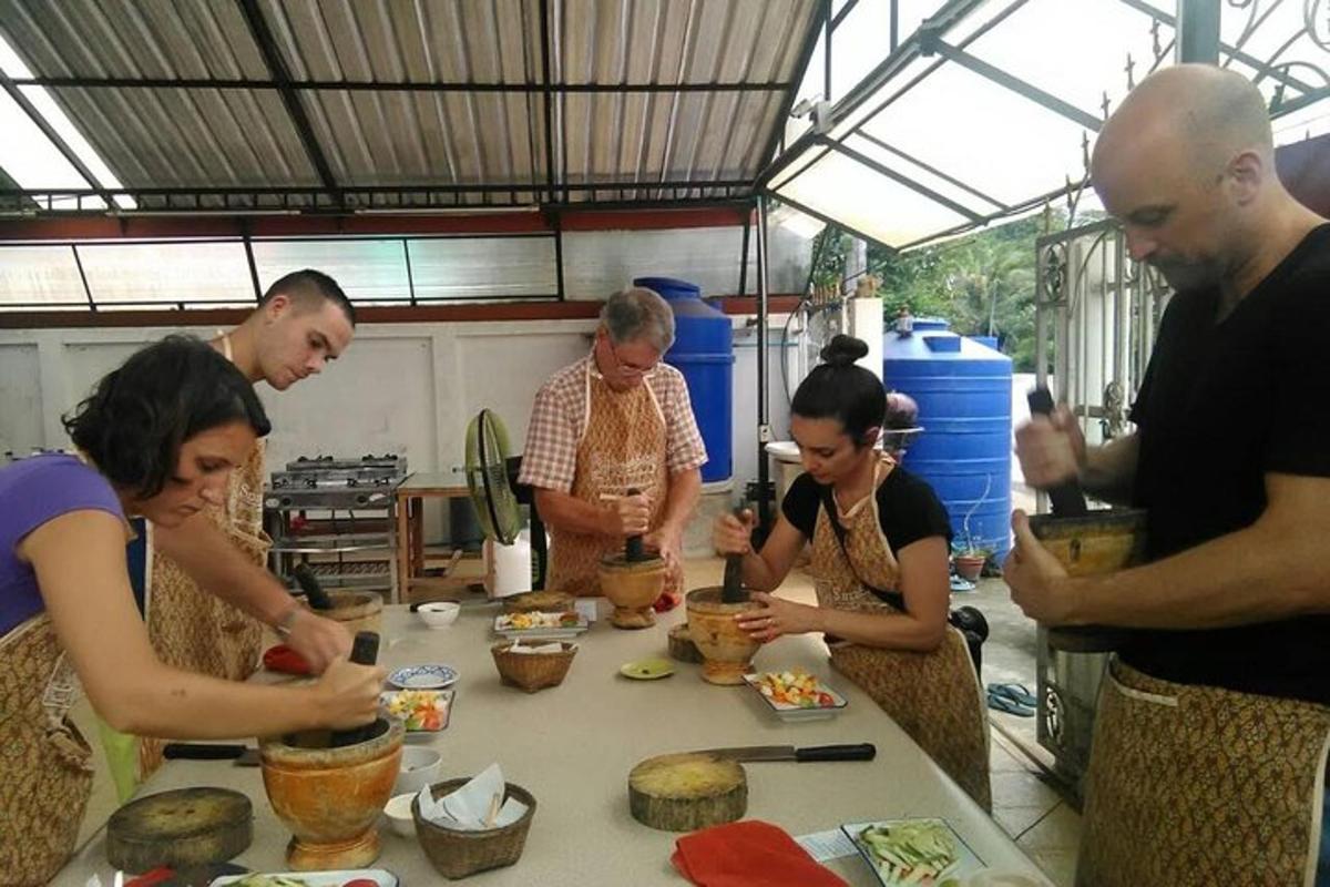 un grup de persones al voltant d'una taula preparant menjar