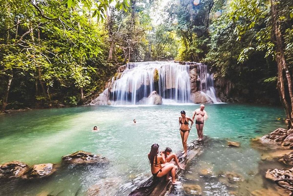 un gruppo di persone in acqua davanti a una cascata