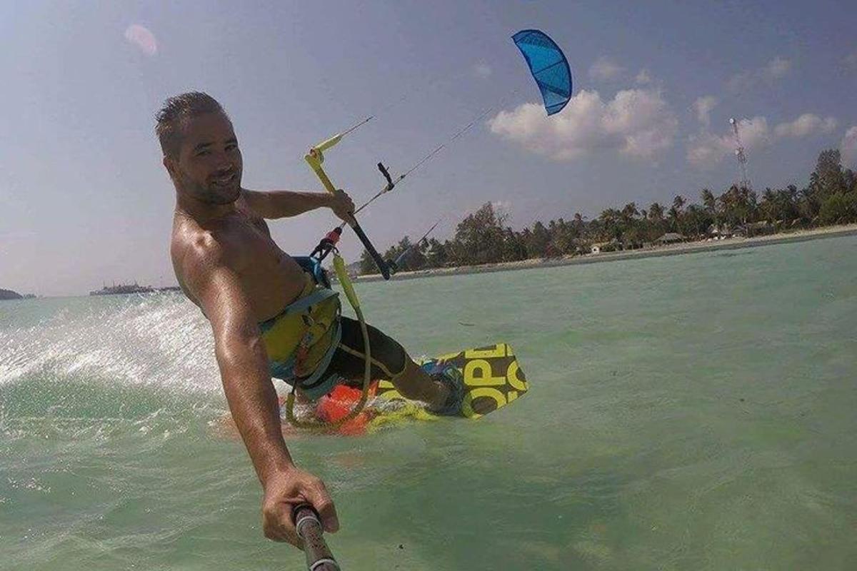 a man in the water holding onto a kite