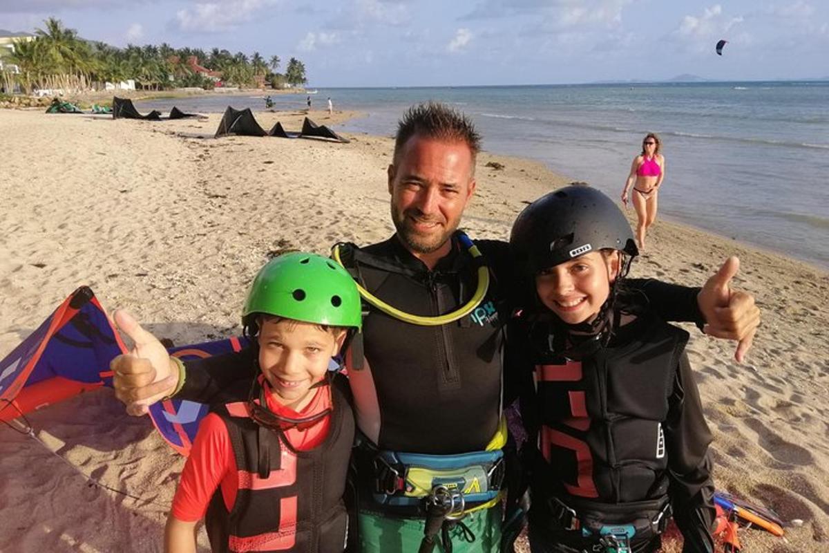 een man en twee jongens staan op een strand
