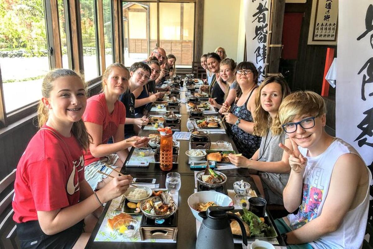 un gruppo di persone sedute a un lungo tavolo che mangiano cibo