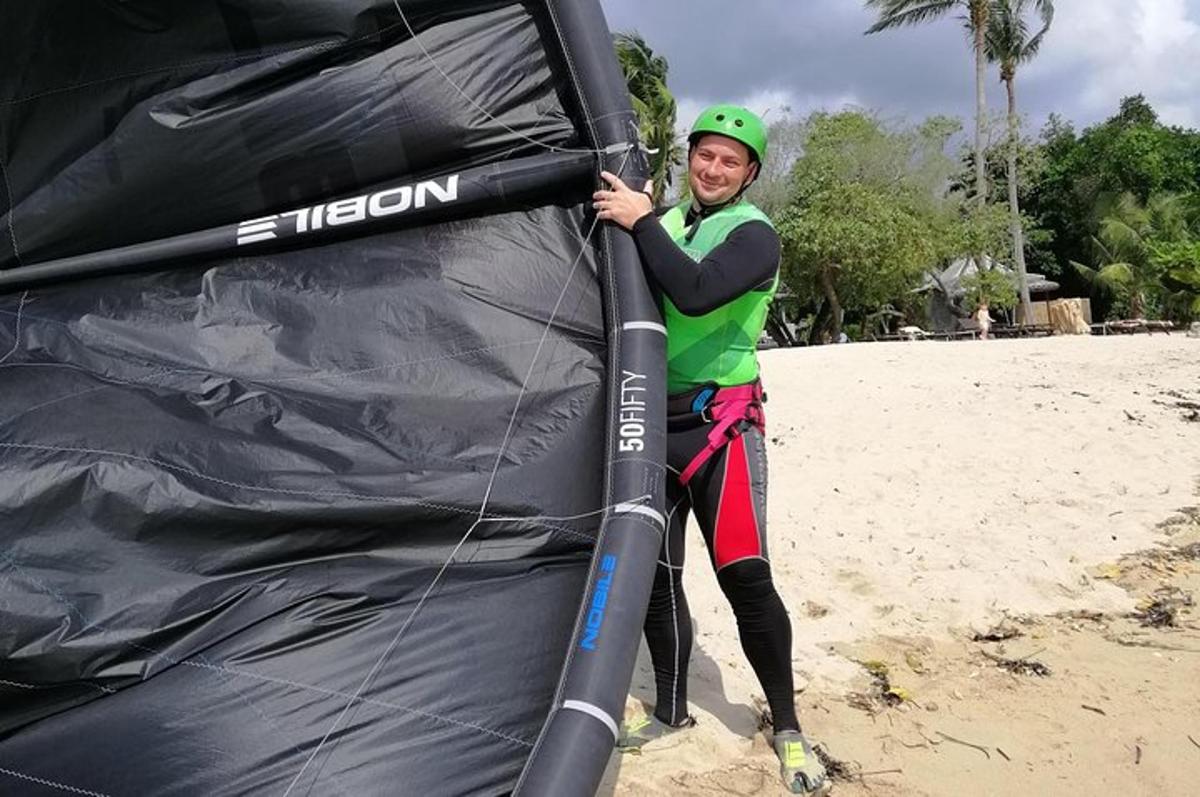 una donna è in piedi accanto a un aquilone sulla spiaggia