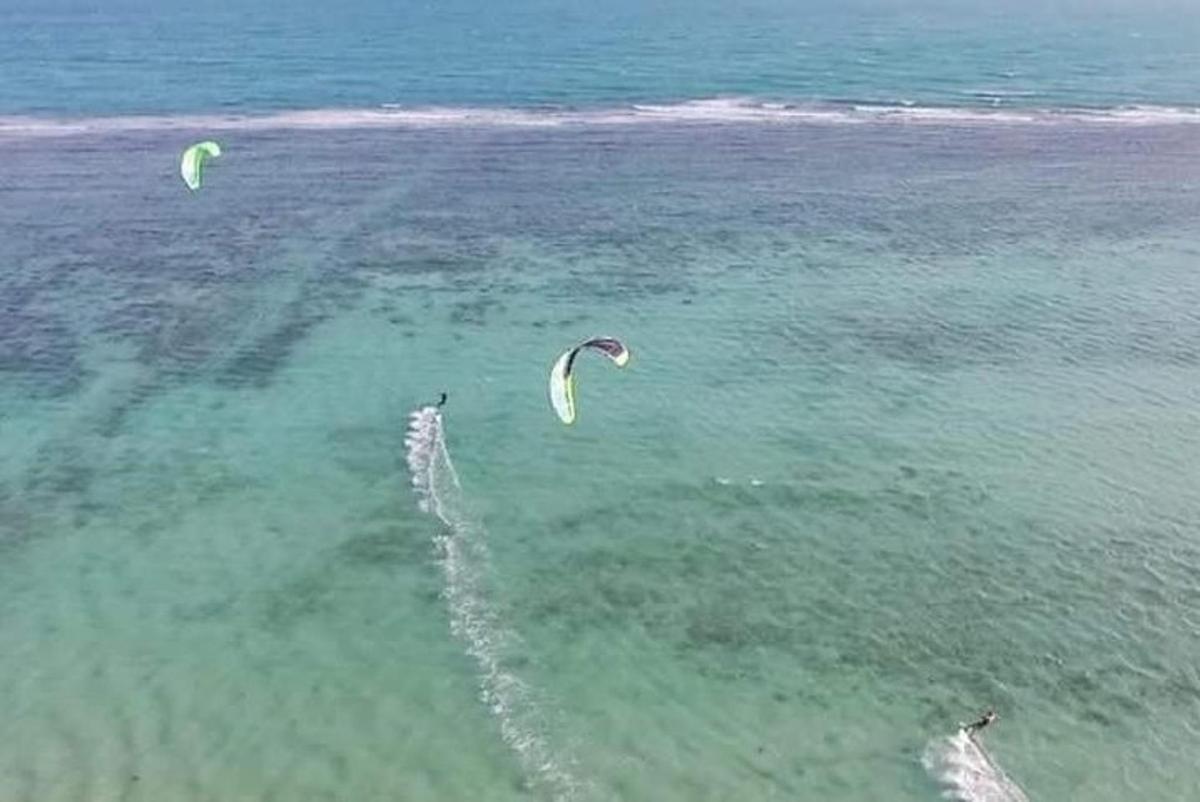 due persone stanno facendo volare aquiloni nell'acqua