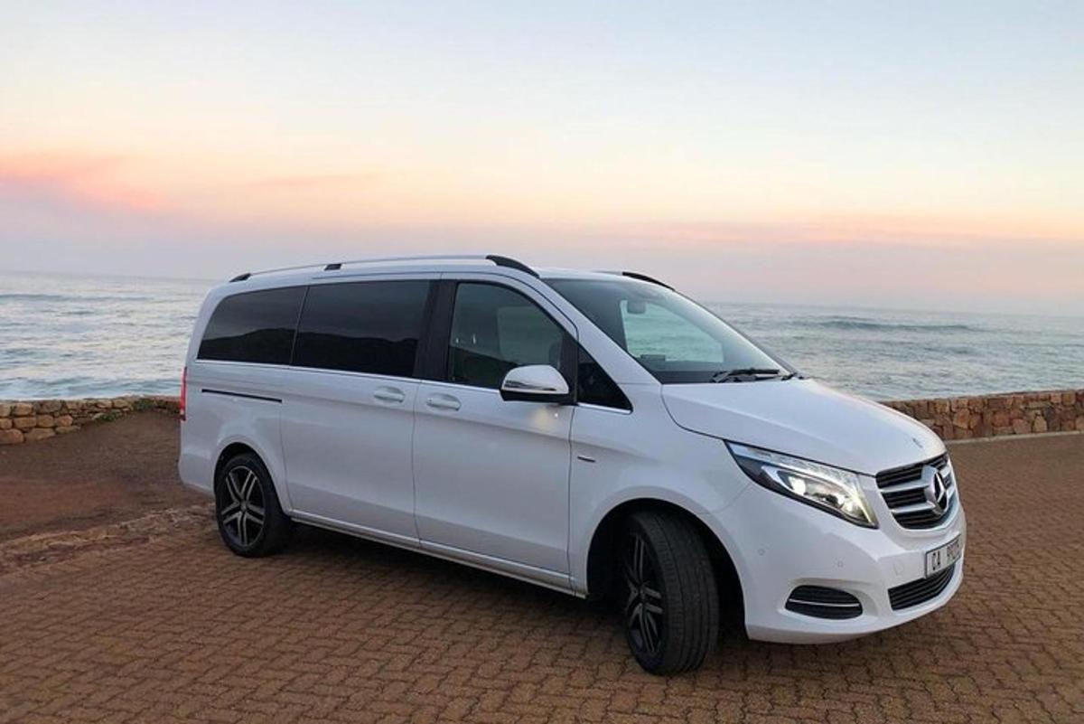 Una camioneta blanca estacionada junto al océano