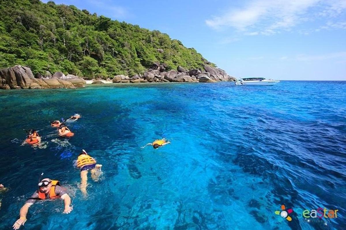 skupina lidí plave v modrém oceánu