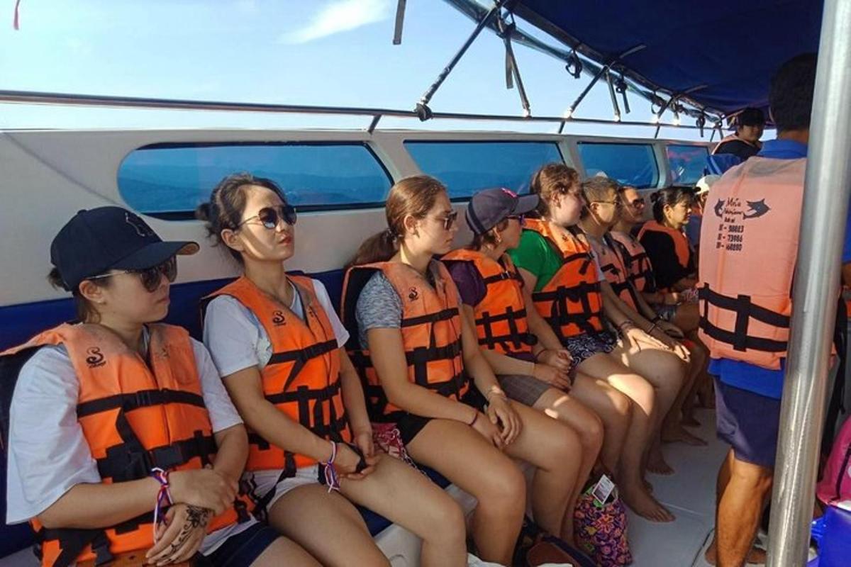 un gruppo di persone con giubbotti di salvataggio su una barca