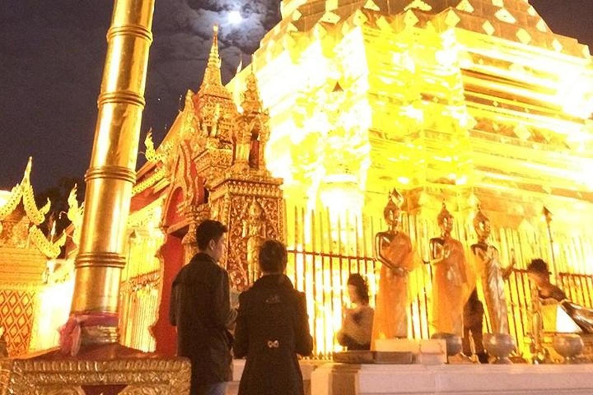 un grup de persones dempeus davant d'un edifici a la nit