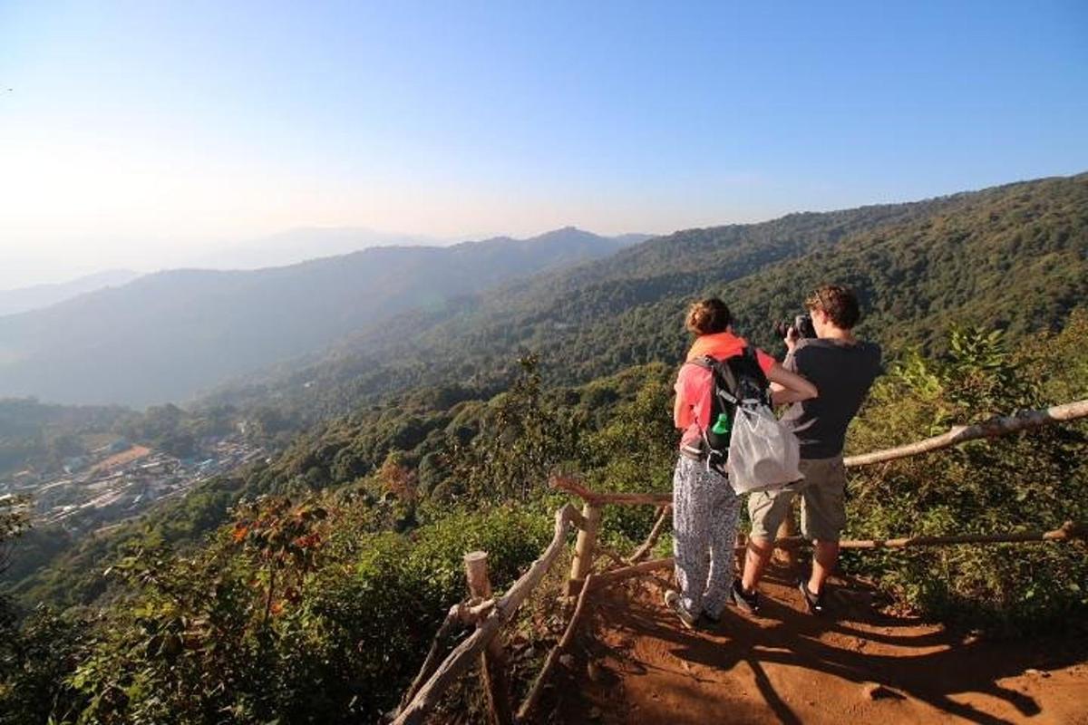 two people standing on top of a mountain taking a picture