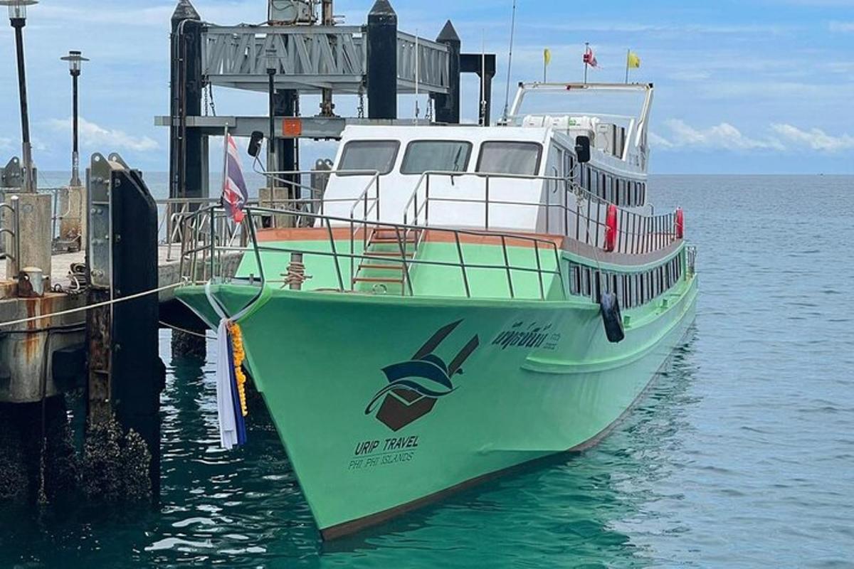 a green and white boat docked at a dock