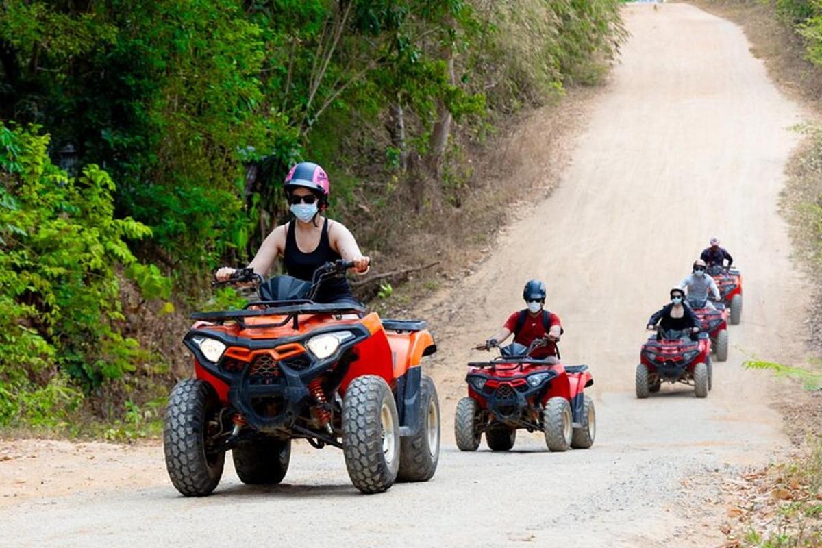 a group of people riding atvs on a dirt road