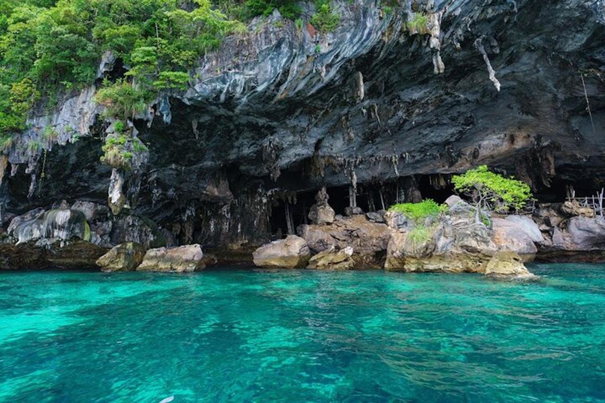 isang pool ng asul na tubig sa harap ng isang kuweba