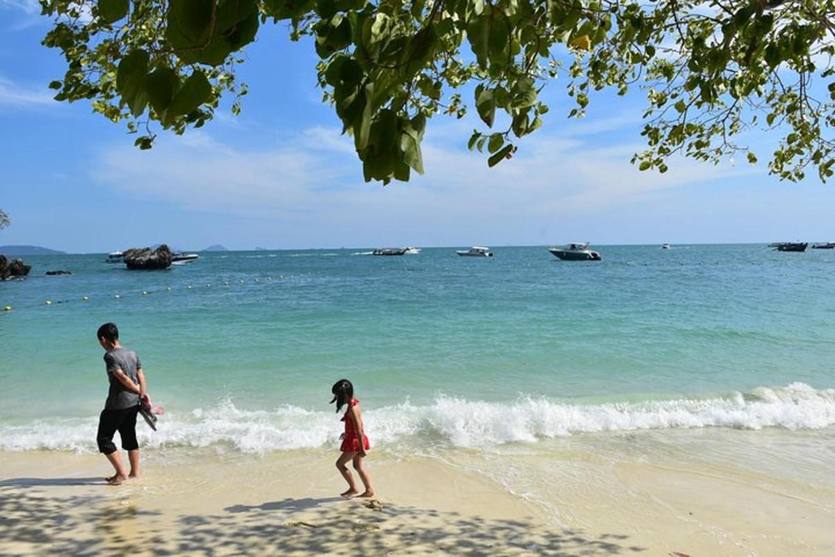 Un hombre y una niña caminando por la playa