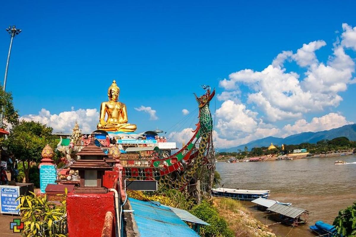 a buddha statue sitting next to a river