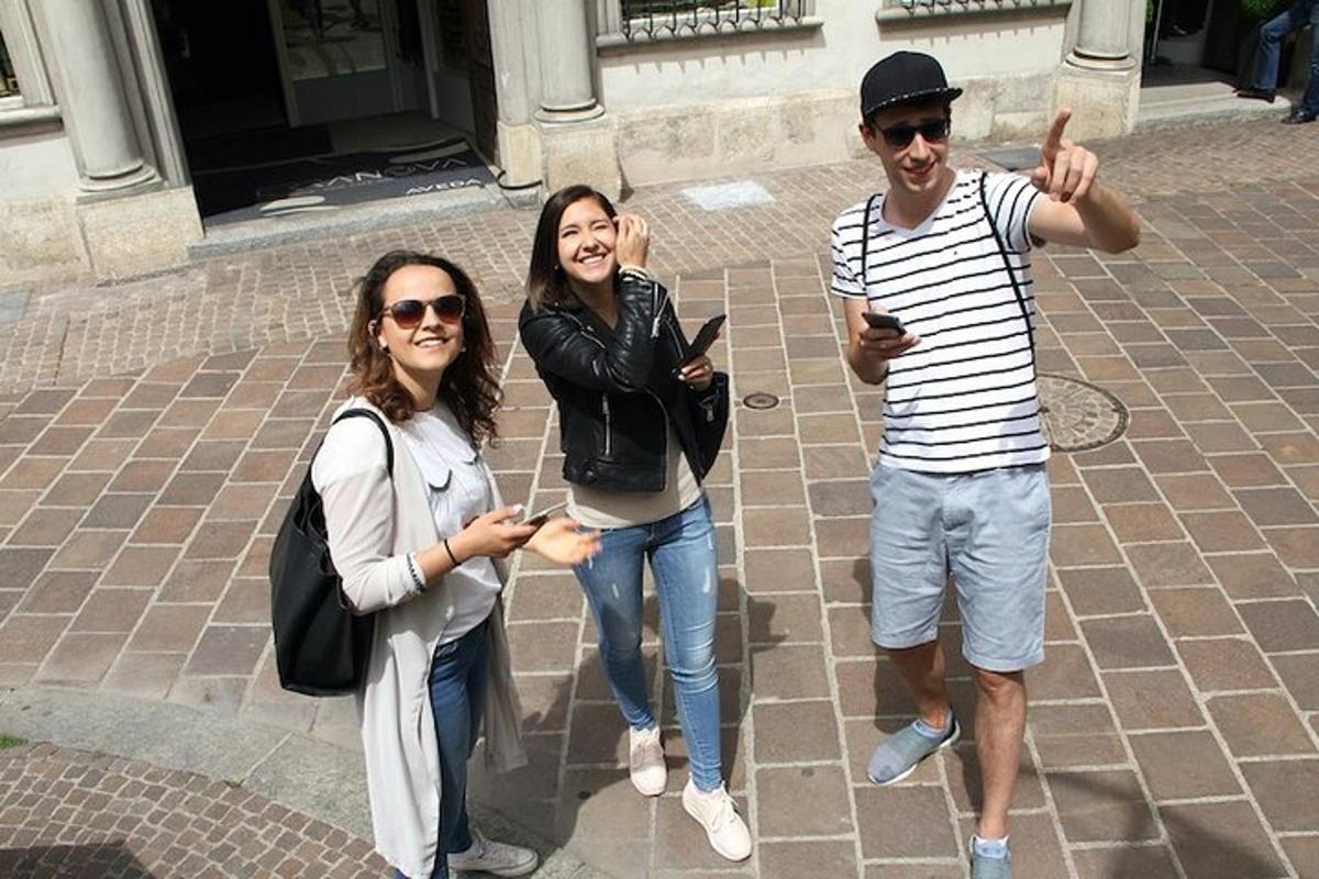 two women and a man posing for a picture with their cell phones