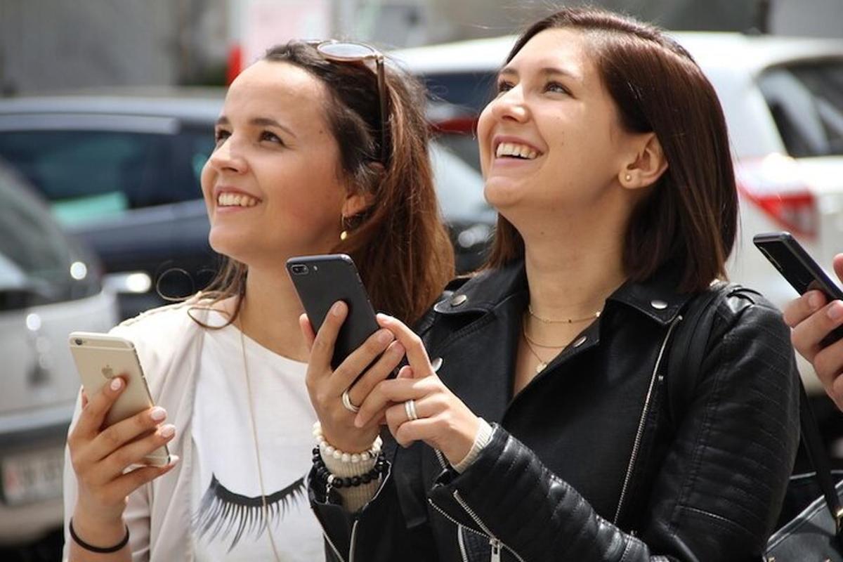 two women are looking at their cell phones