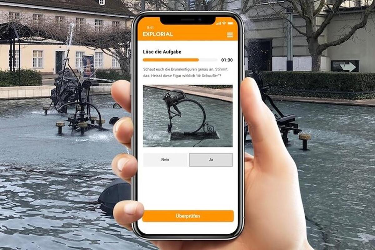 a hand holding a cell phone in front of a fountain