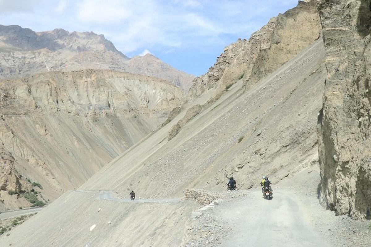 Dos personas viajando en motocicleta por una carretera de montaña