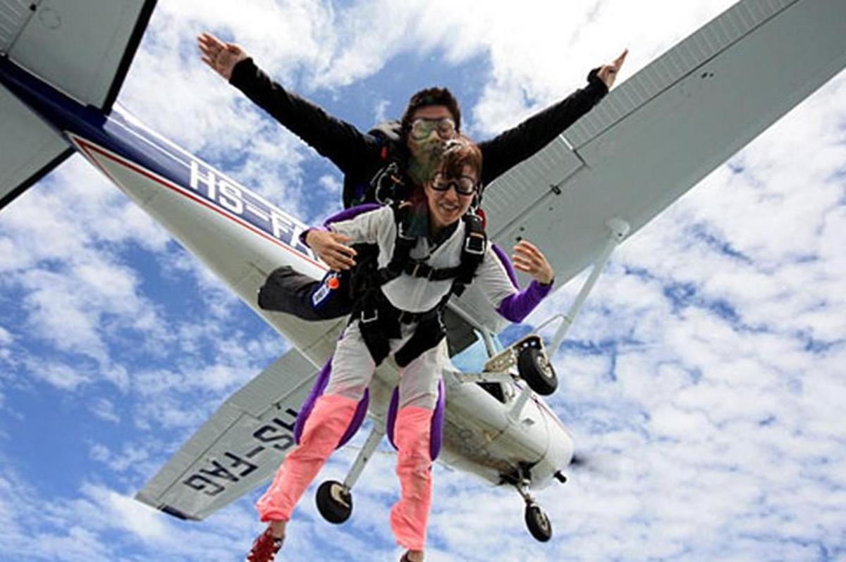 duas pessoas estão saltando de um pequeno avião