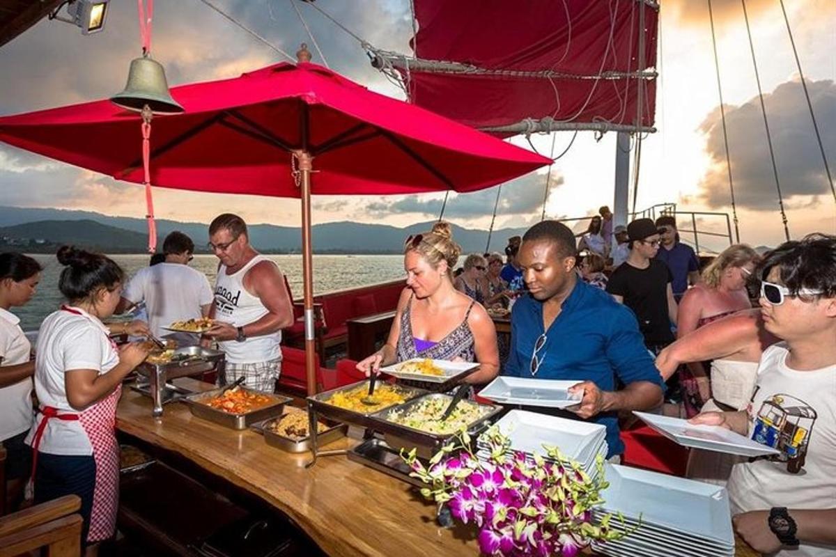 un gruppo di persone che mangiano cibo su una barca