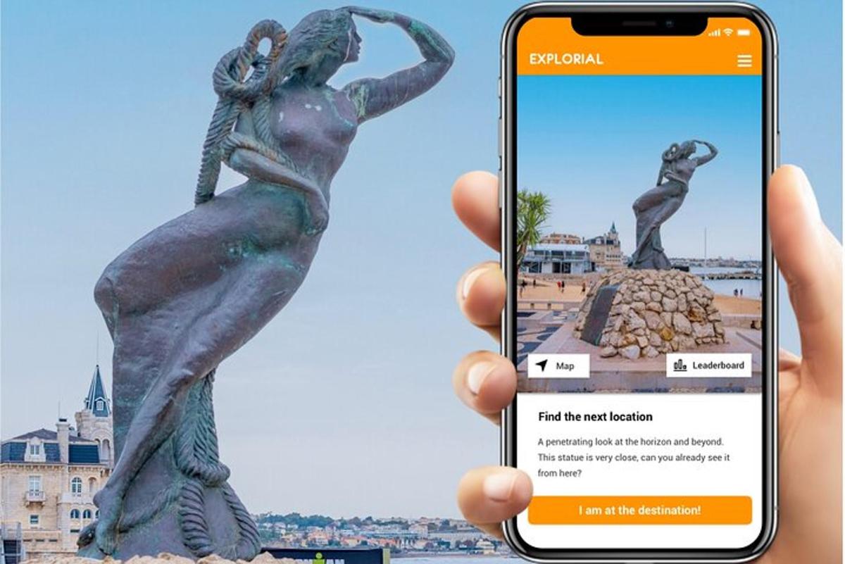 una persona che tiene in mano un telefono cellulare davanti a una statua