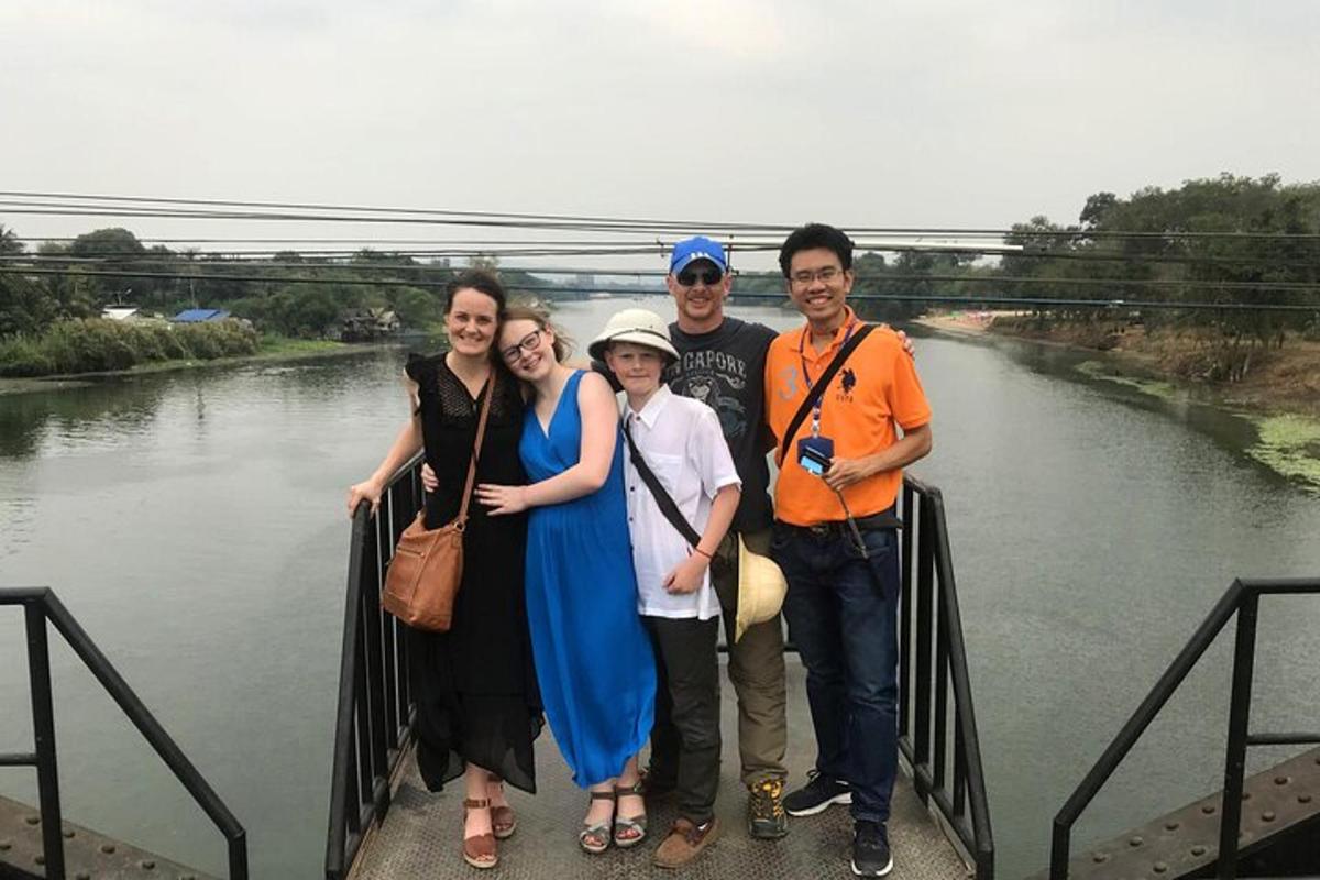 un gruppo di persone in piedi su un ponte sopra un fiume