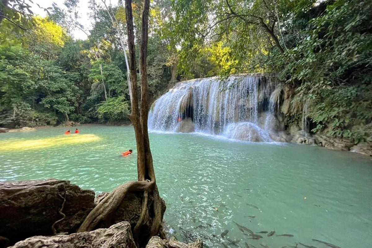 una cascata in un lago con persone che ci nuotano dentro