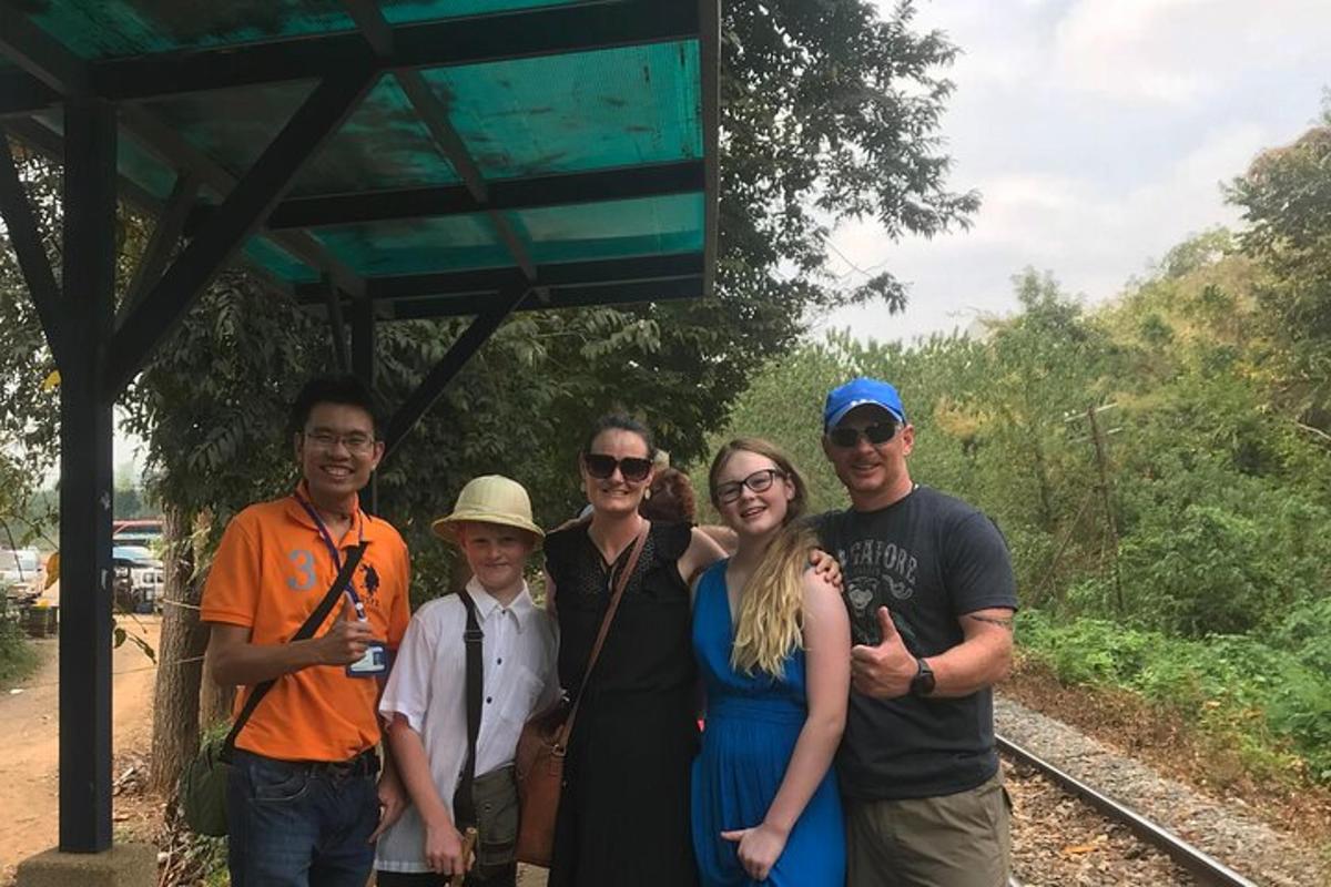 un gruppo di persone in posa per una foto in una stazione ferroviaria