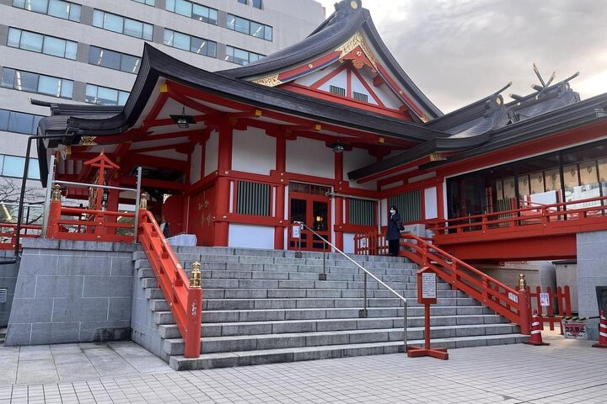 Un templo rojo con escaleras frente a un edificio.