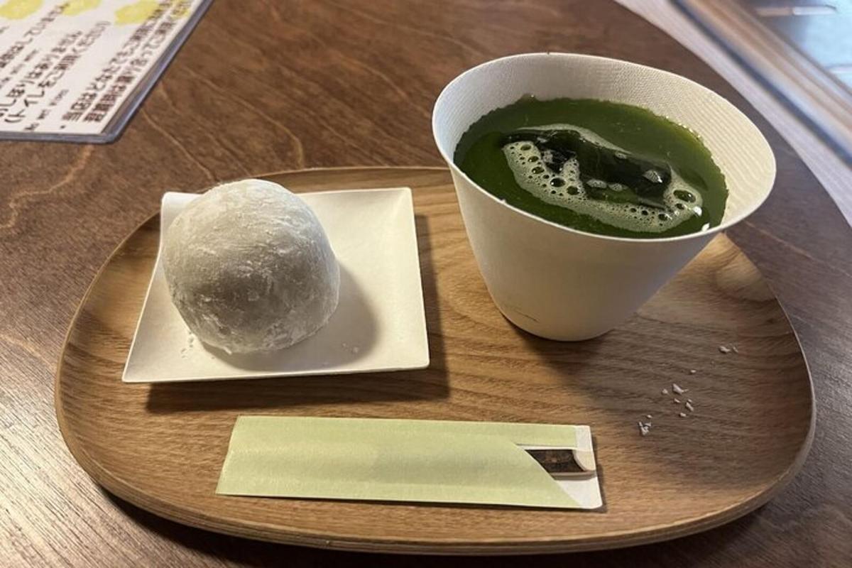 Un plato con una taza de té verde y una pelota.