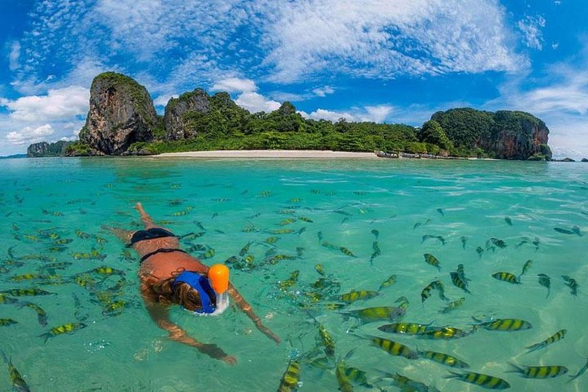 a man swimming in the water near a island